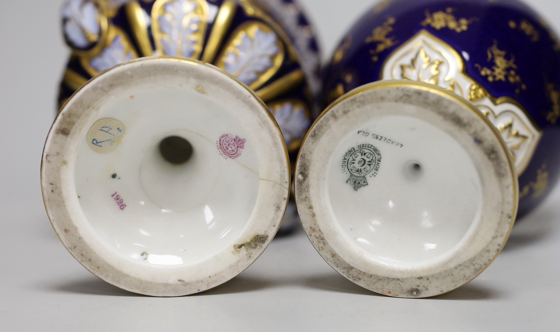 A Royal Worcester two handled vase with fruit on a blue ground by Hawkins, signed, marked LEADLESS GLAZE, date code 1901 together with a Royal Worcester vase, painted by Sebright, signed, date code 1913 (later a/f). Tall